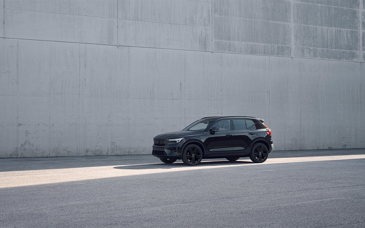 black Volvo EX40 driving on a street