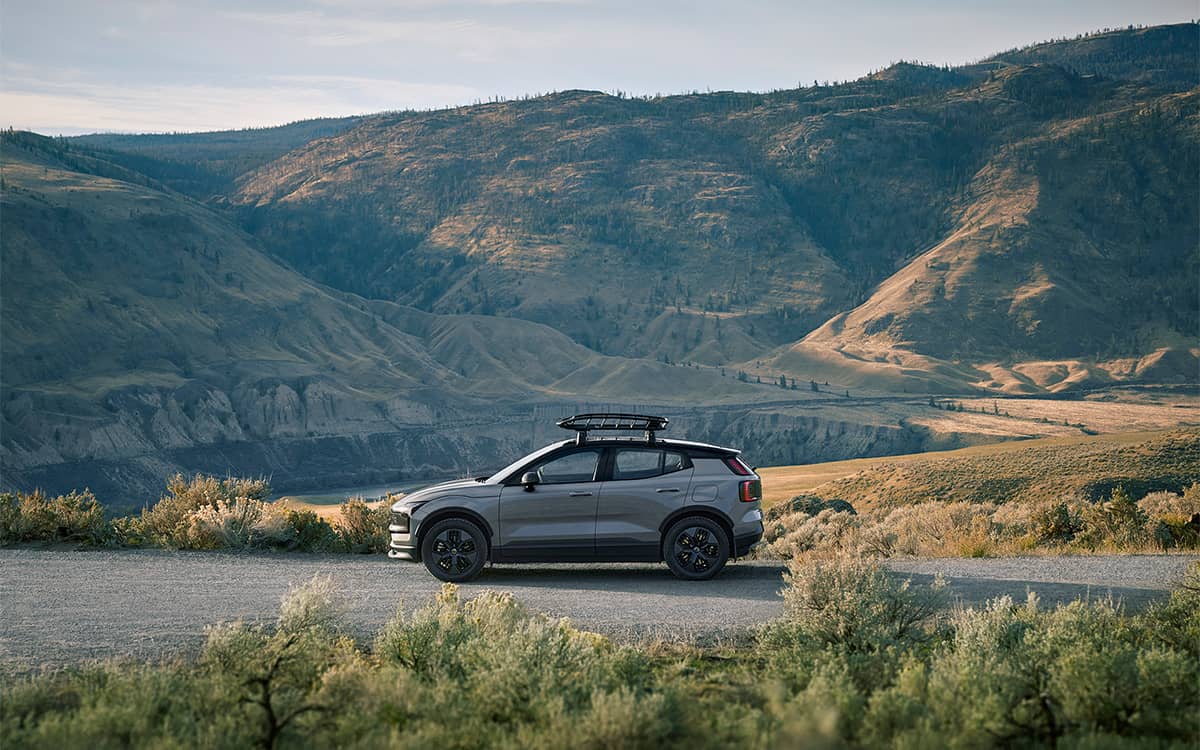 Grey Volvo EX30 with roof rack, surrounded by a vast mountain landscape