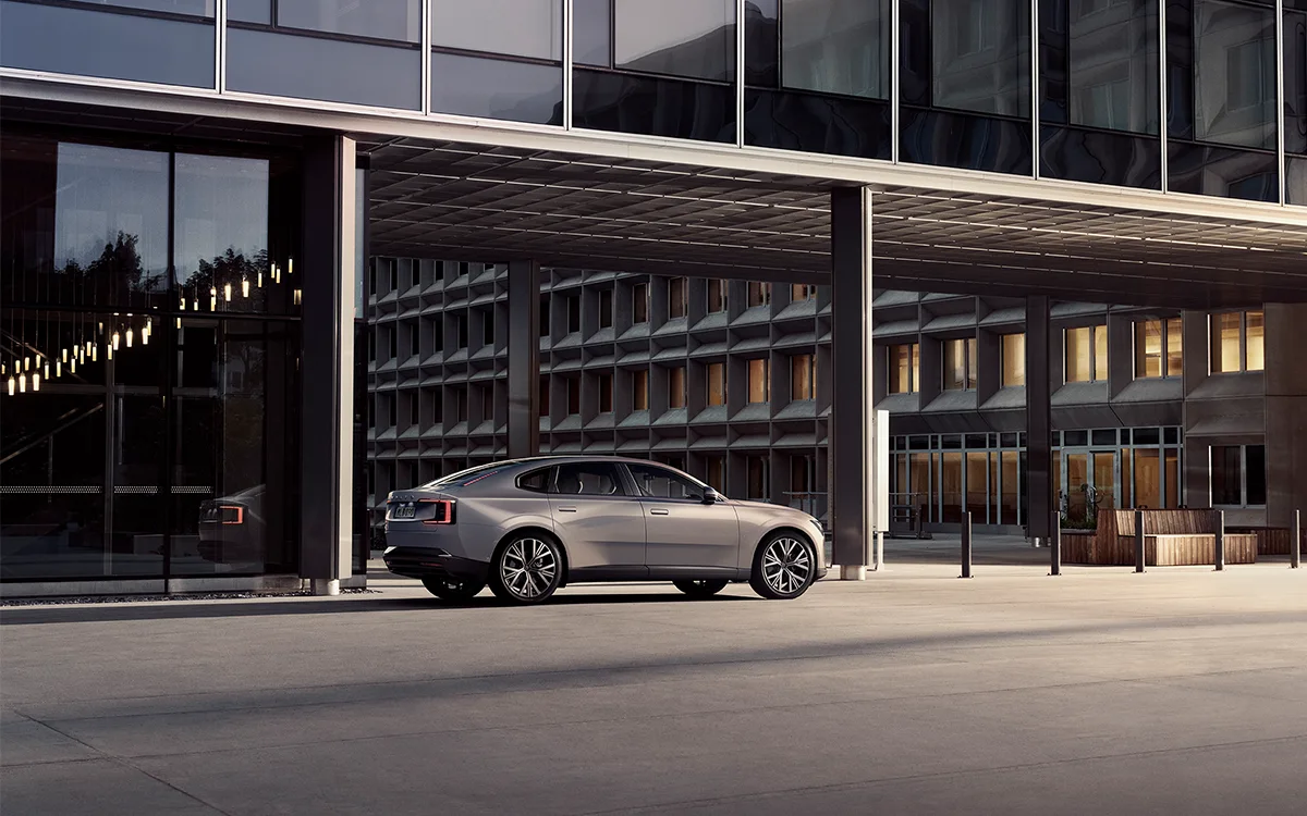 Silver Volvo ES90 in front of a modern office building
