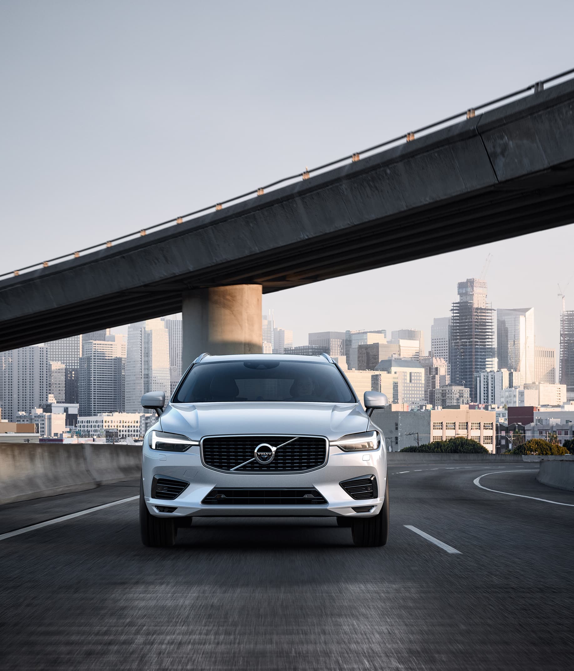 Volvo XC60 Plug-in Hybrid fährt auf einer Strasse in einer Stadt
