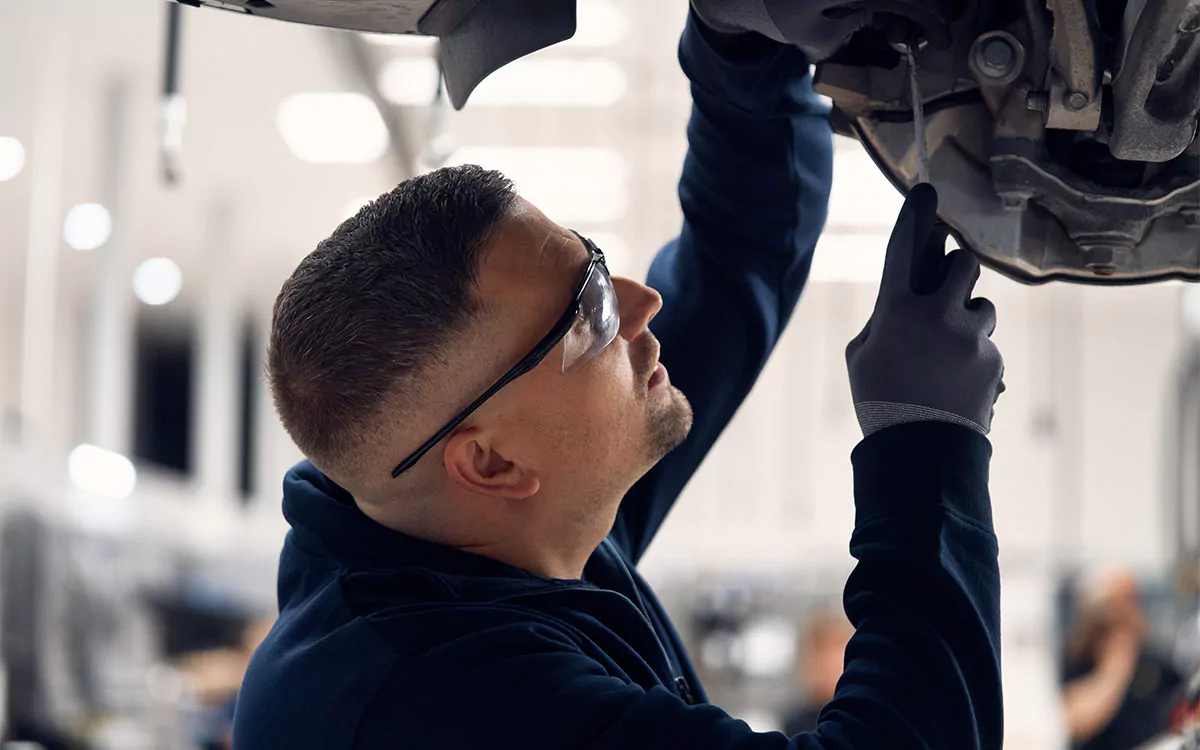 Mechaniker bei der Wartung eines Fahrzeugs in einer Autowerkstatt in Zug
